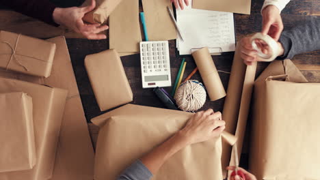 hands wrapping packages for postage from above