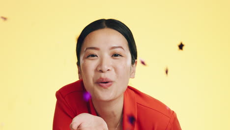 studio, asian woman blowing confetti