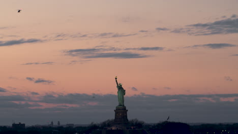 Estatua-De-La-Libertad,-Enmarcada-En-El-Centro,-Bajo-Un-Cielo-Rosa-Intenso