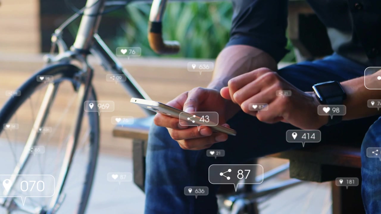 Man on bench tapping phone checking watch as incoming likes shares pins rising for social media