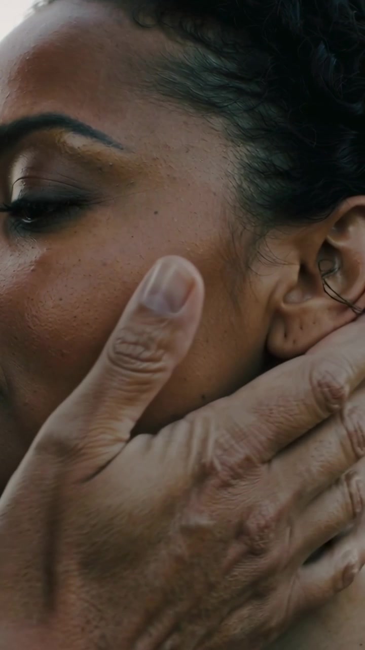 Vertical video: Reaching man's hand tucking hair, sliding to jaw, cupping cheek outdoors caring