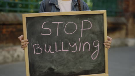 Child holding a sign protesting bullying