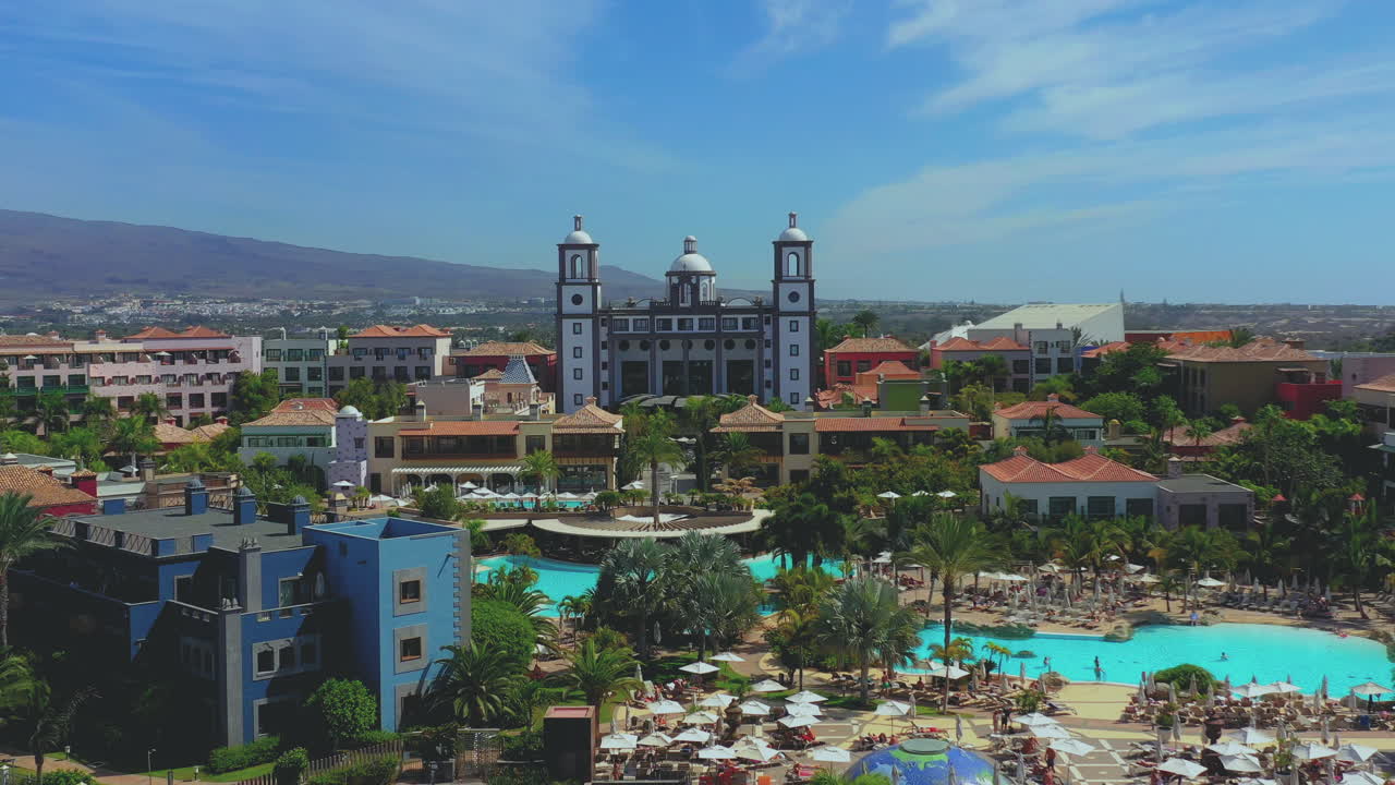 Aerial view of outstanding resorts near the beach, with palms. Rotating aerial view of tropical beach with resorts, palms and swimming pools.