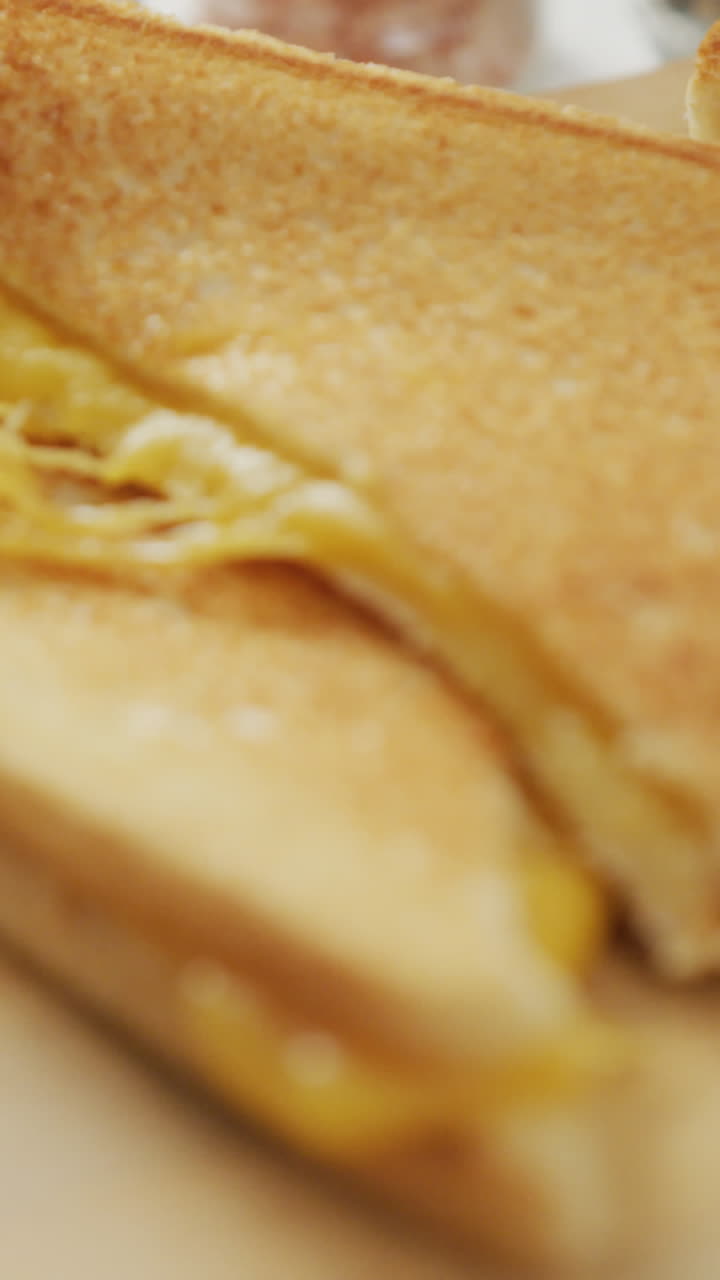 video de primer plano de un sándwich de pan blanco con queso recién preparado en una tabla de madera