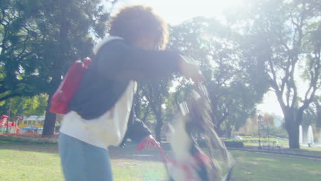 woman playing tug-of-war with dog in public park