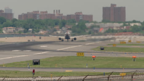 tilt up from highway to airport runway with plane taking off in distance