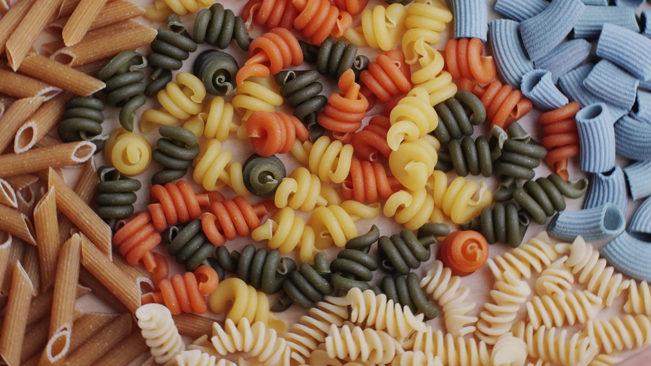 Assortment of Multicolored Raw Pasta in Various Shapes