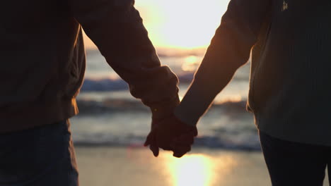 silueta de la playa, puesta de sol y pareja caminando