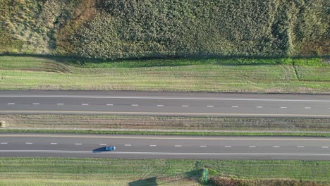 Aerial-drone-top-down-shot-over-vehicle-movement-along-two-way-main-road-at-daytime