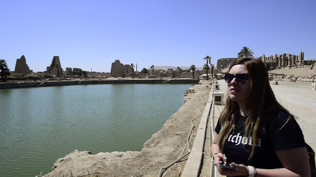 Un viaggiatore scatta foto nel Tempio di Karnak in Egitto. Una ragazza viaggiatrice scatta foto con il telefono