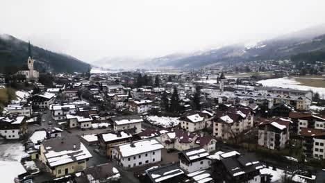 Snowy-rooftops-of-Kirchberg-township-in-Austria,-aerial-drone-view