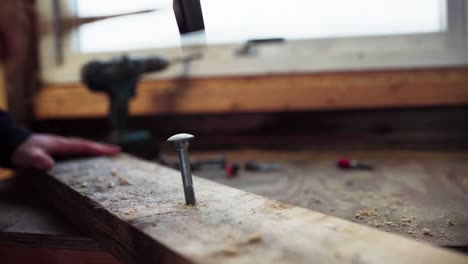 Persona-Martillando-Tornillo-De-Madera-En-Una-Tabla-De-Madera