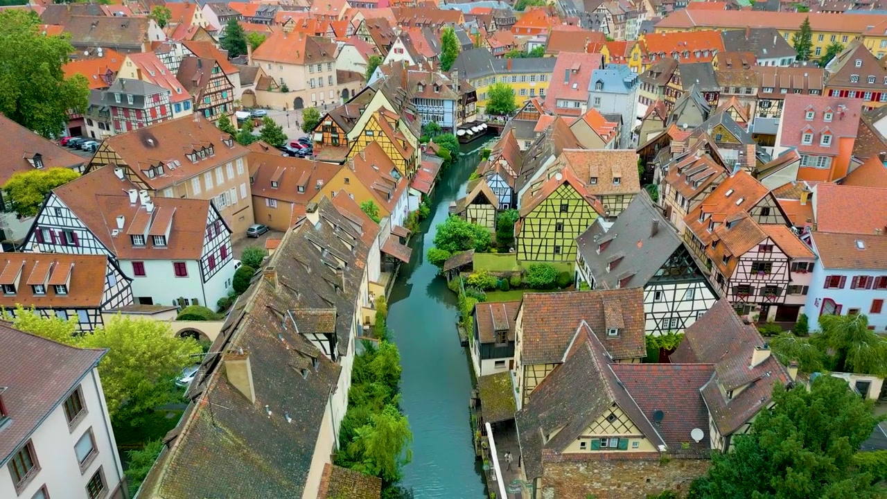 Video aereo 4K con drone delle case a graticcio lungo il fiume Lauch che si snoda attraverso la zona della Piccola Venezia a Colmar, Francia