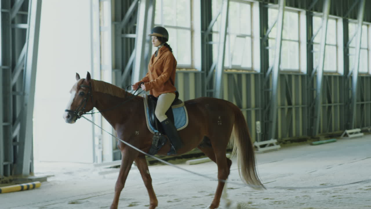 Woman Learning Horseback Riding in Equestrian School