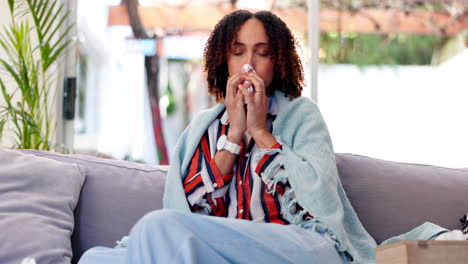 woman with a cold blowing her nose on couch