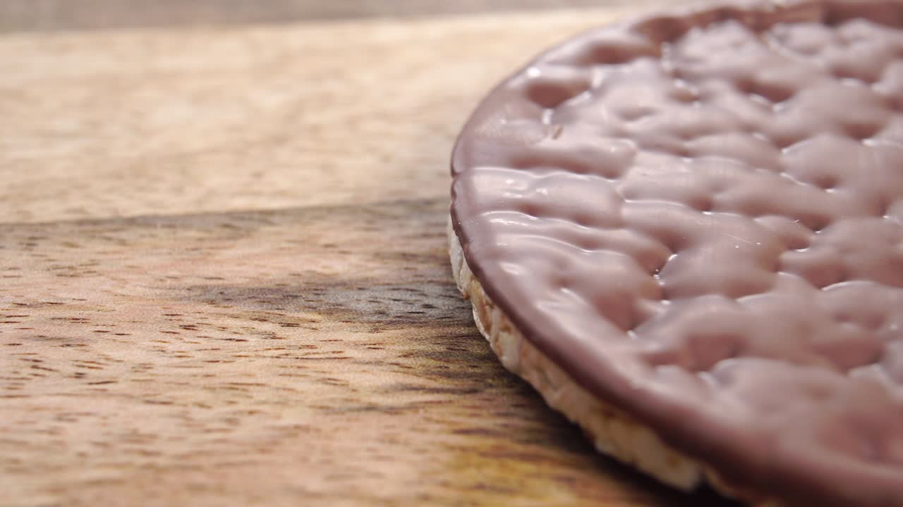 pastel de arroz crujiente con una capa de chocolate en una superficie de madera rústica