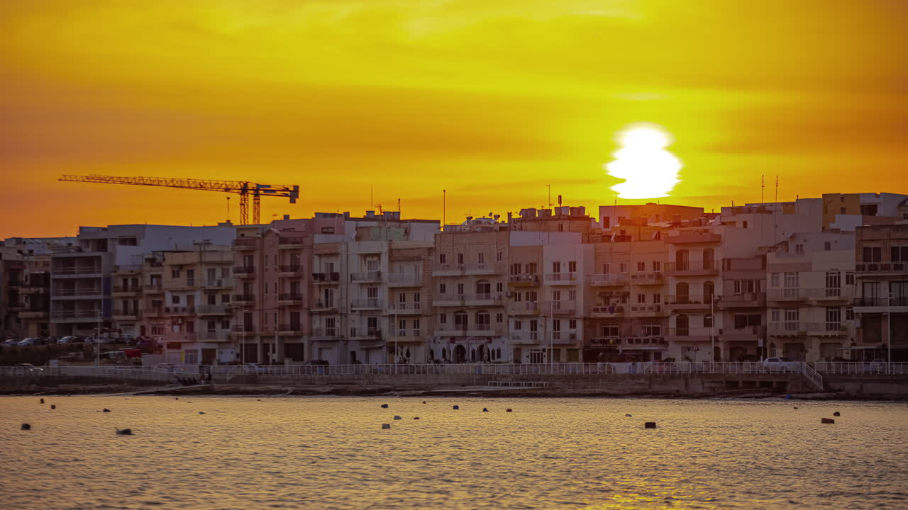 A spectacular sunset provides an unrealistic picture of the harbor and houses at Gira, in Malta's Central Region, between Msida and Sliema
