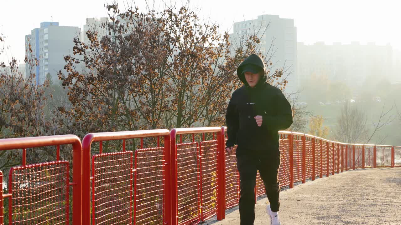 Individual Jogging on Bridge During Sunrise