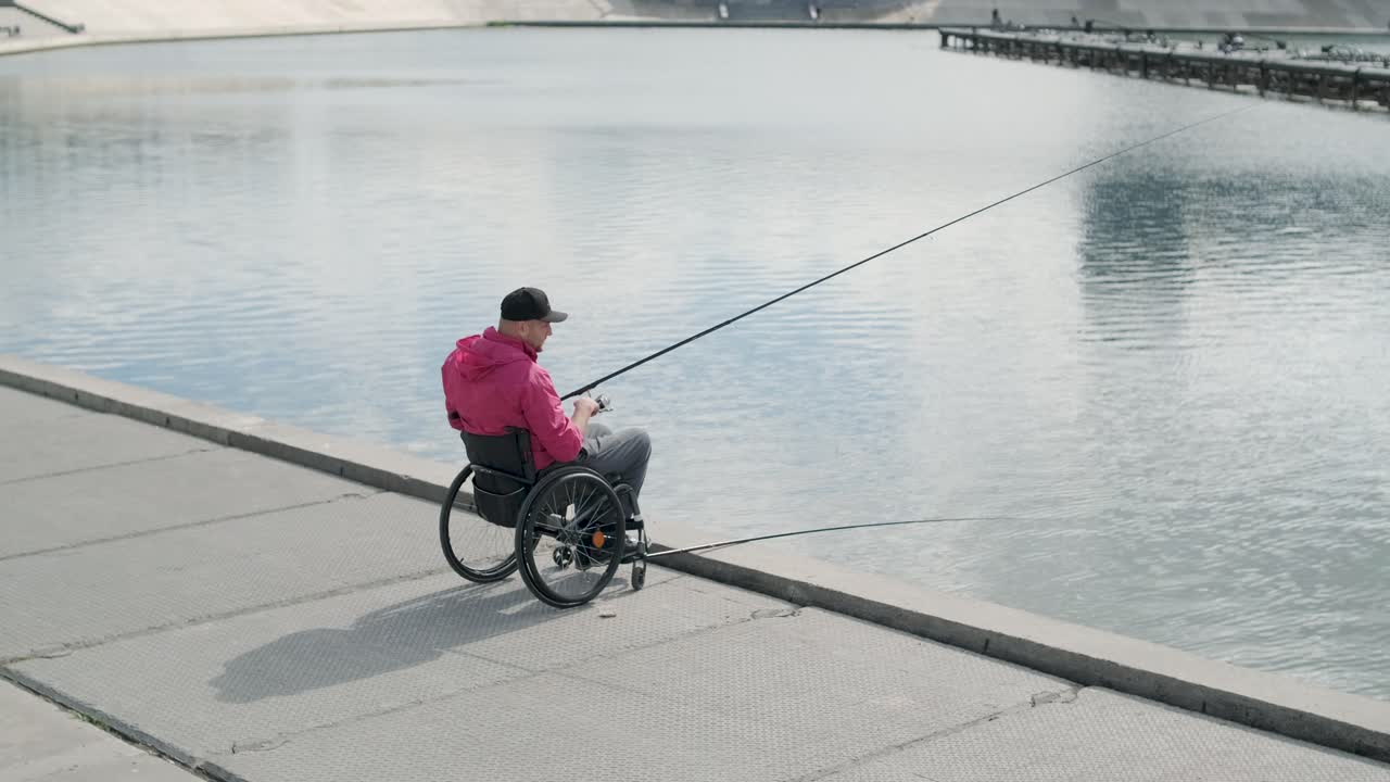persona con discapacidad física que utiliza silla de ruedas para pescar en el muelle de pesca