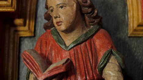 a wooden, colorfully painted statue of a saint in a church in central europe, captured in 4k resolution