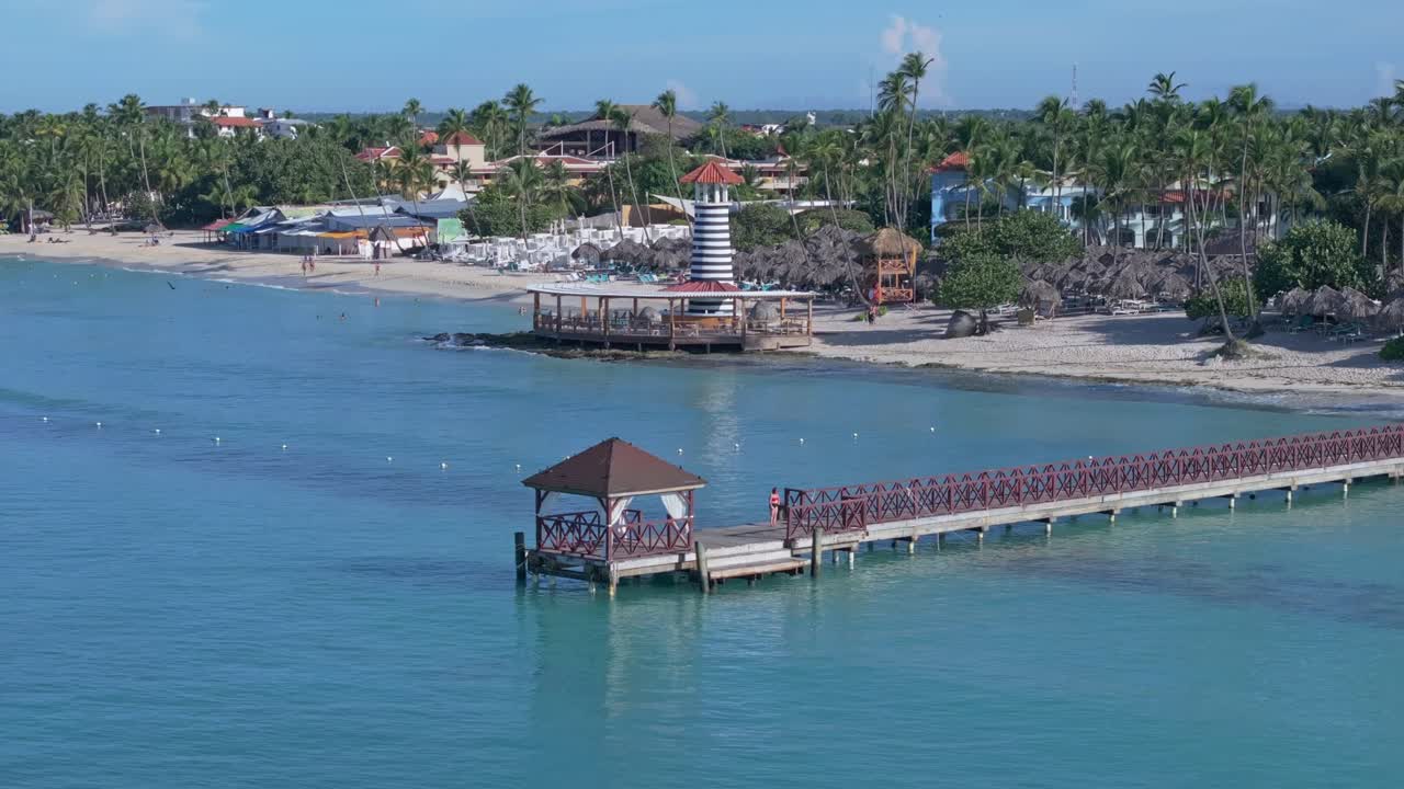 Long pier and lighthouse bar on Playa Dominicus beach in Dominican Republic