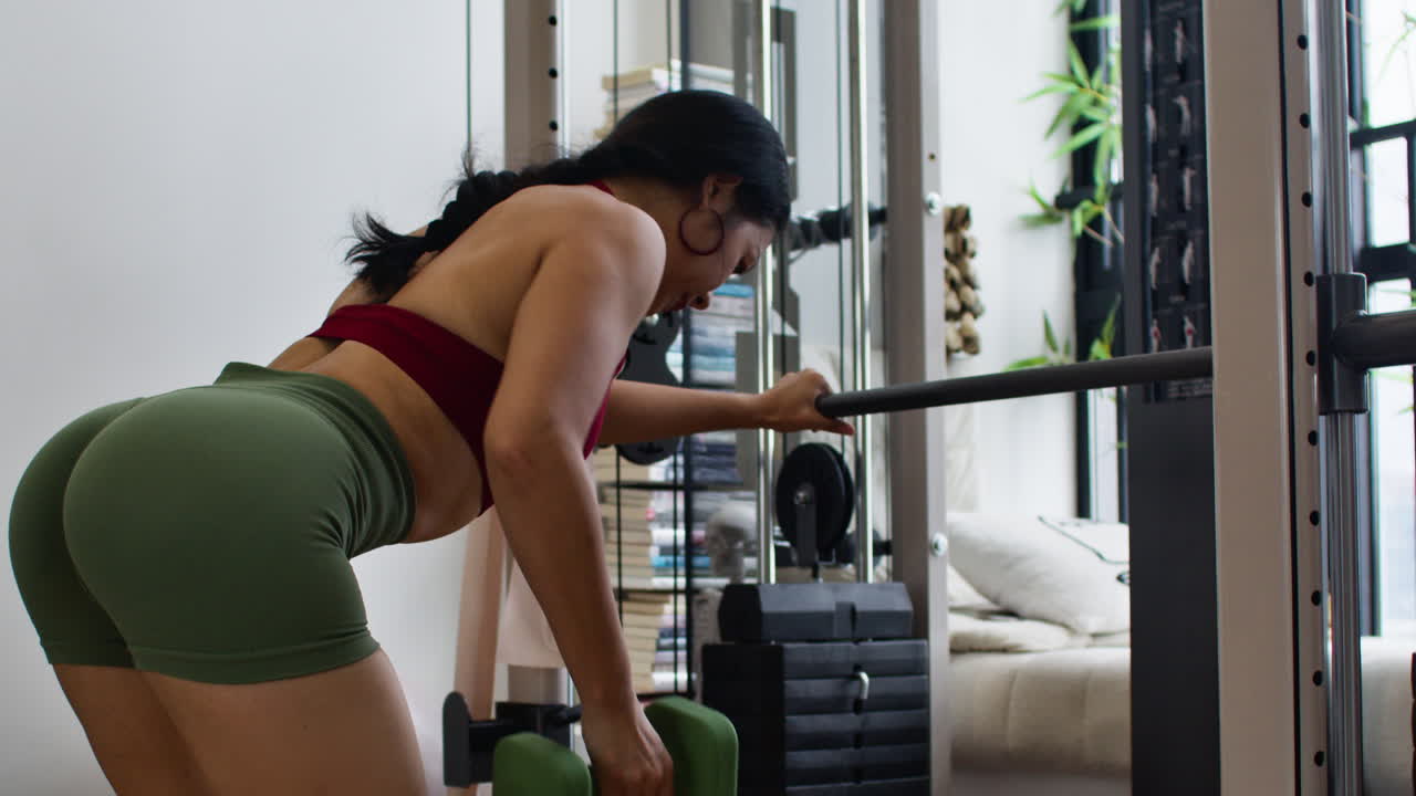 Woman working out with dumbbells and smith machine