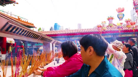 people offering incense at a vibrant temple