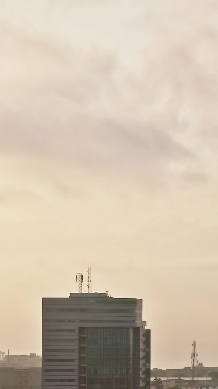 Paisaje urbano de Accra, Ghana, al atardecer, con edificios altos y nubes