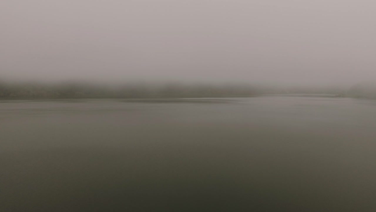 Mist over calm lake with distant shoreline Sao Miguel Azores