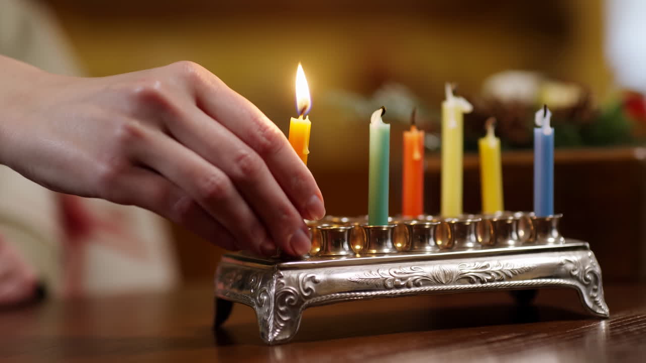 Hand Lighting a Candle on a Menorah for Hanukkah Celebration