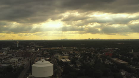 slow flight towards the evening, golden sunset using a dolly shot forward past a freshly painted water tower in the suburbs of long island, new york
