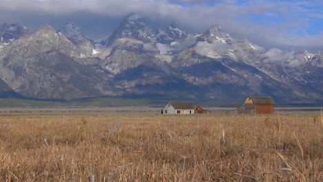 an old barn rises out of a prairie with the grand tetons in the background 6