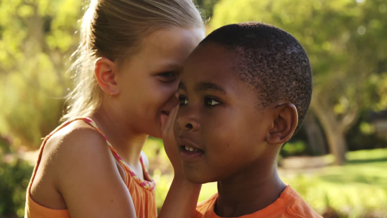 chica susurrando un secreto en el oído de los niños