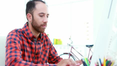 Casual-businessman-working-at-his-desk