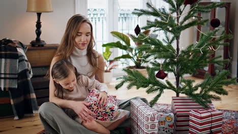 Familia-Feliz-Recibiendo-Regalos-En-Una-Casa-Acogedora.-Niña-Recibiendo-Regalos-De-Su-Madre