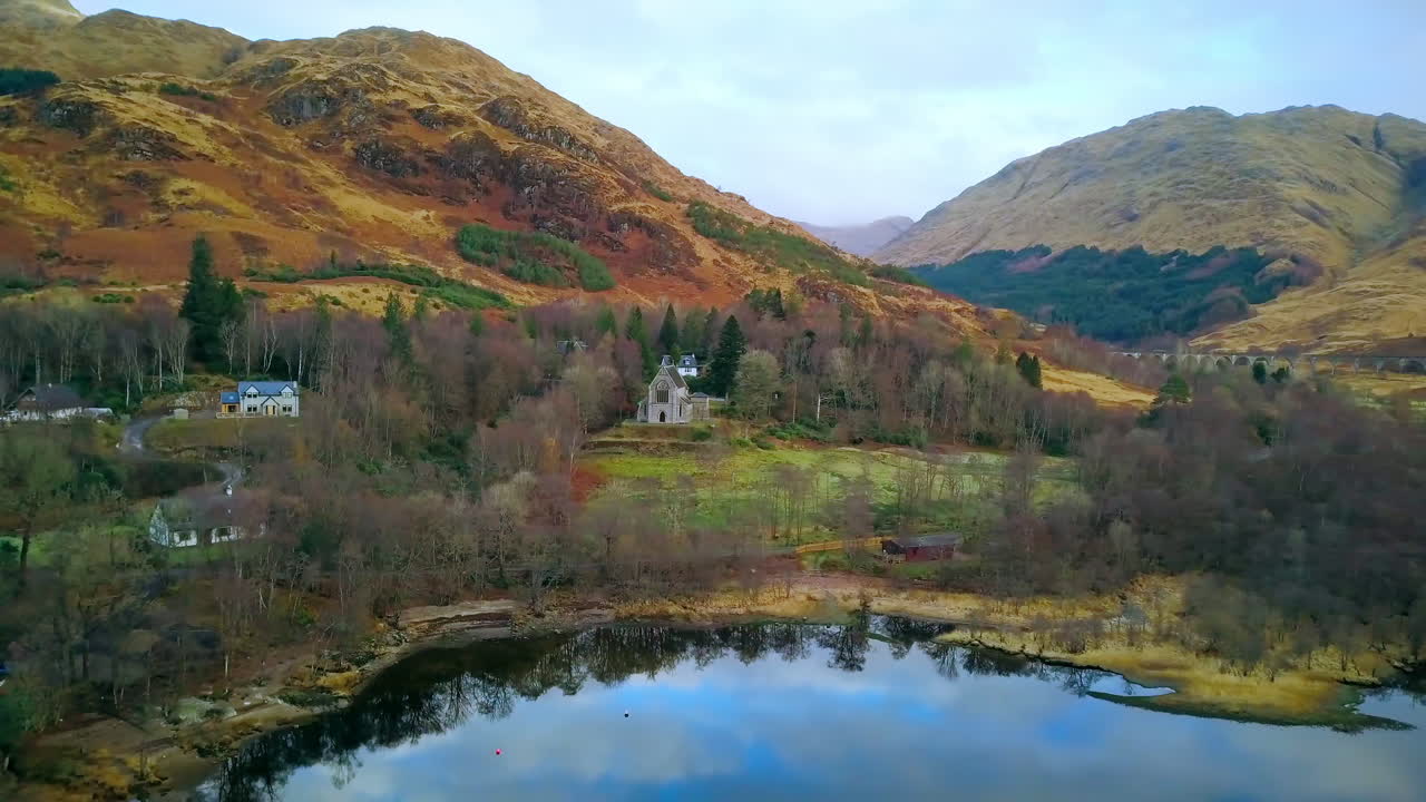 toma aérea volando desde el lago hasta la iglesia, escocia