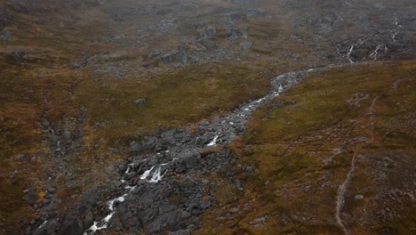 Aerial-view-of-a-long-waterfall-flowing-toward-the-sea-outside-Nuuk,-Greenland