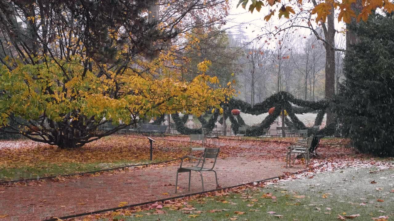 Snow falling on the chairs and paths of the Jardin du Luxembourg in Paris