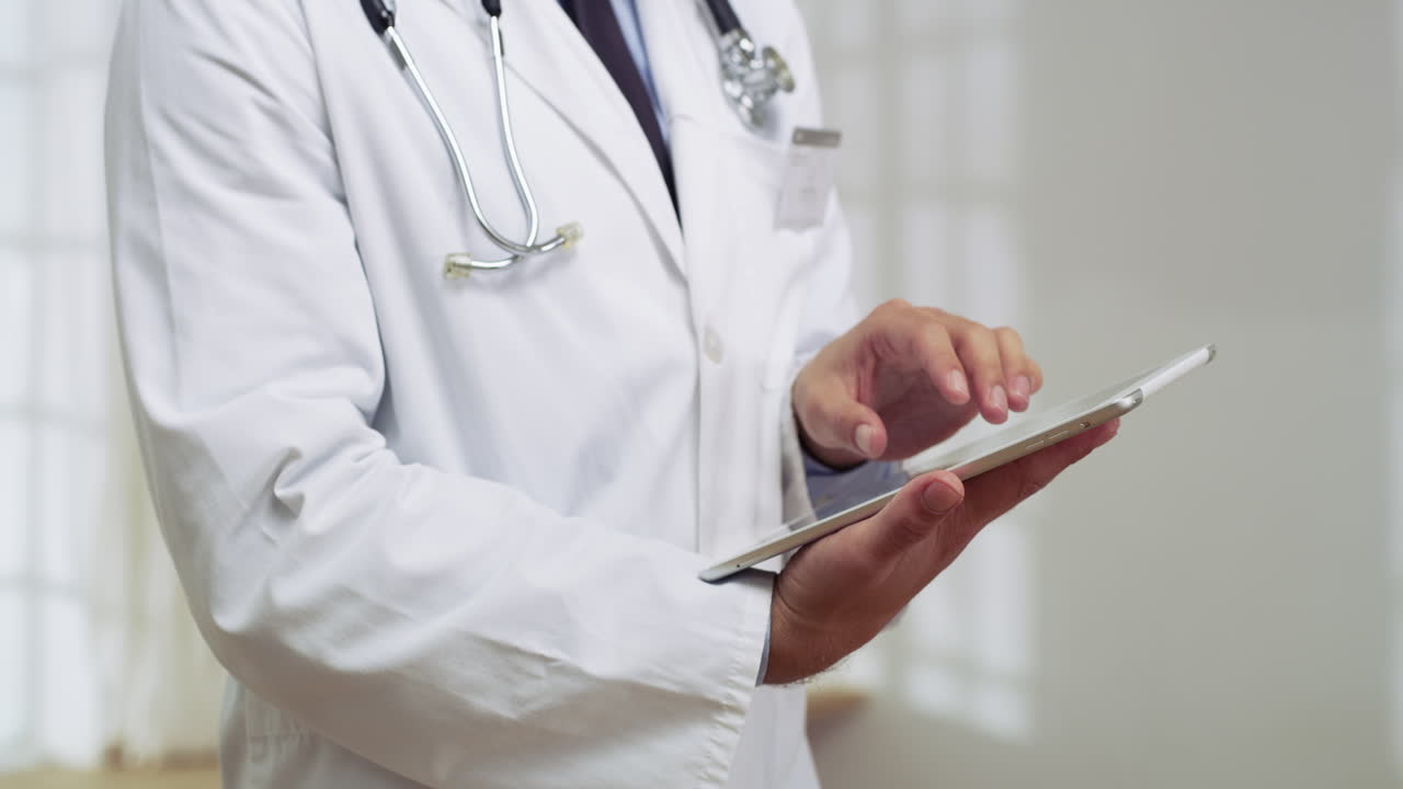 a young male doctor using a digital tablet