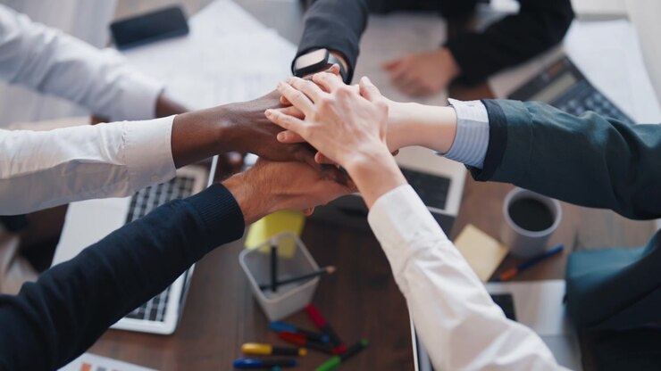 Equipe de negócios diversificada unindo as mãos no escritório
