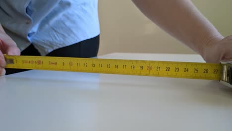 woman using tape measure for measuring surface, close up