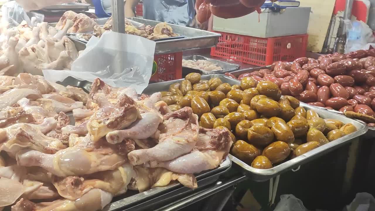 Fresh chicken at the wet market is typically displayed whole or cut, with moist, pink skin and minimal redness.
