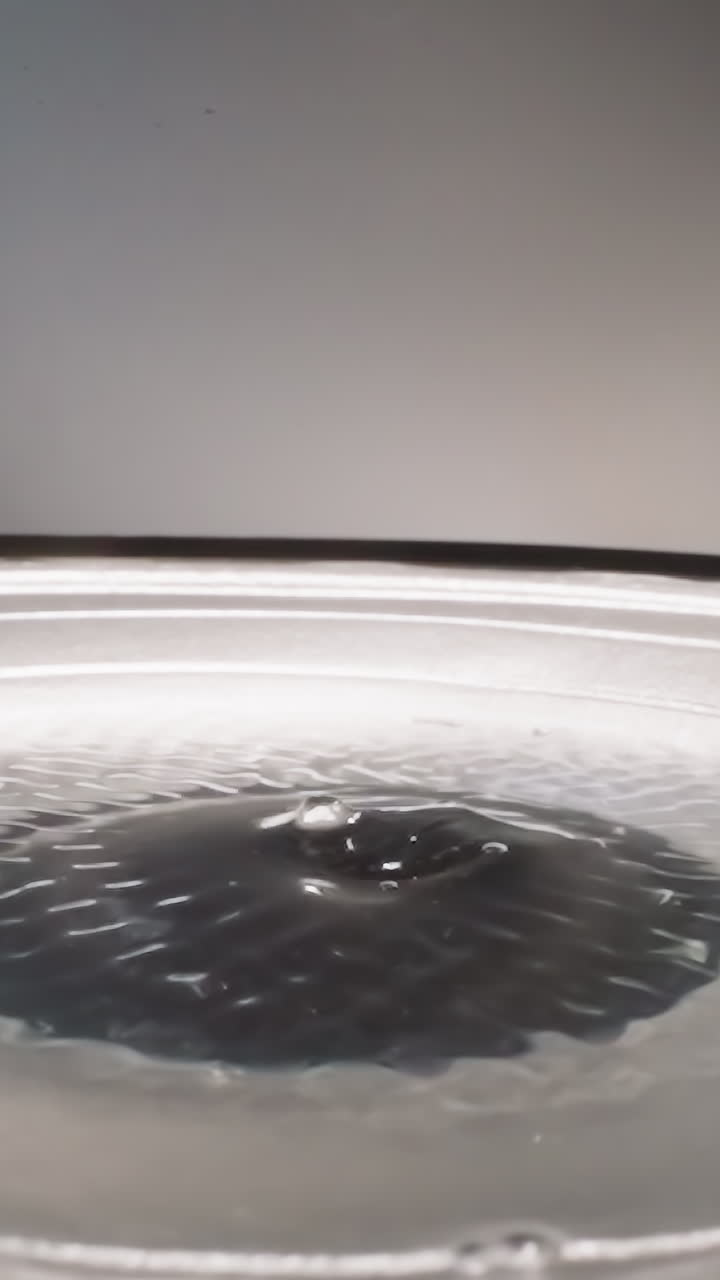 Liquid substance shaking due to frequencies of loud speaker reflecting light. Gooey hyaluronic acid vibrating while sound device operating macro