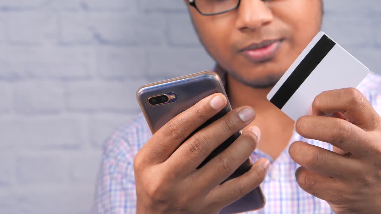 hombre haciendo un pago móvil con una tarjeta de crédito