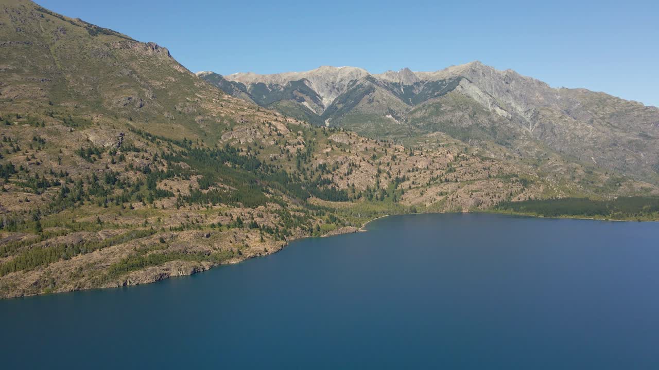 muñeca aérea en el lago epuyen junto a las montañas andinas con bosque de pinos, patagonia argentina