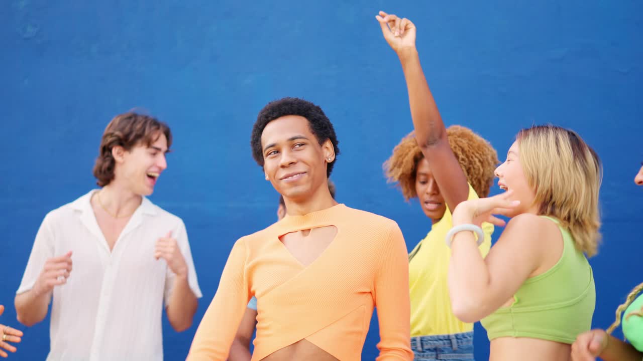 Gay man dancing with multi-ethnic friends outdoors