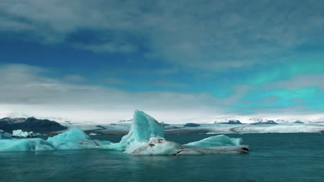 les faibles lumières du nord derrière les nuages au-dessus du lagon glaciaire de jokulsarlon dans le sud de l'islande