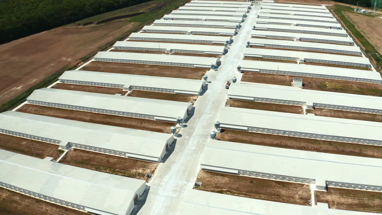 White buildings of manufacturing on the field. View from above on a new industrial complex. Flight over warehouses. Aerial view.