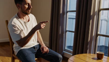 Man Sitting by Window, Pointing