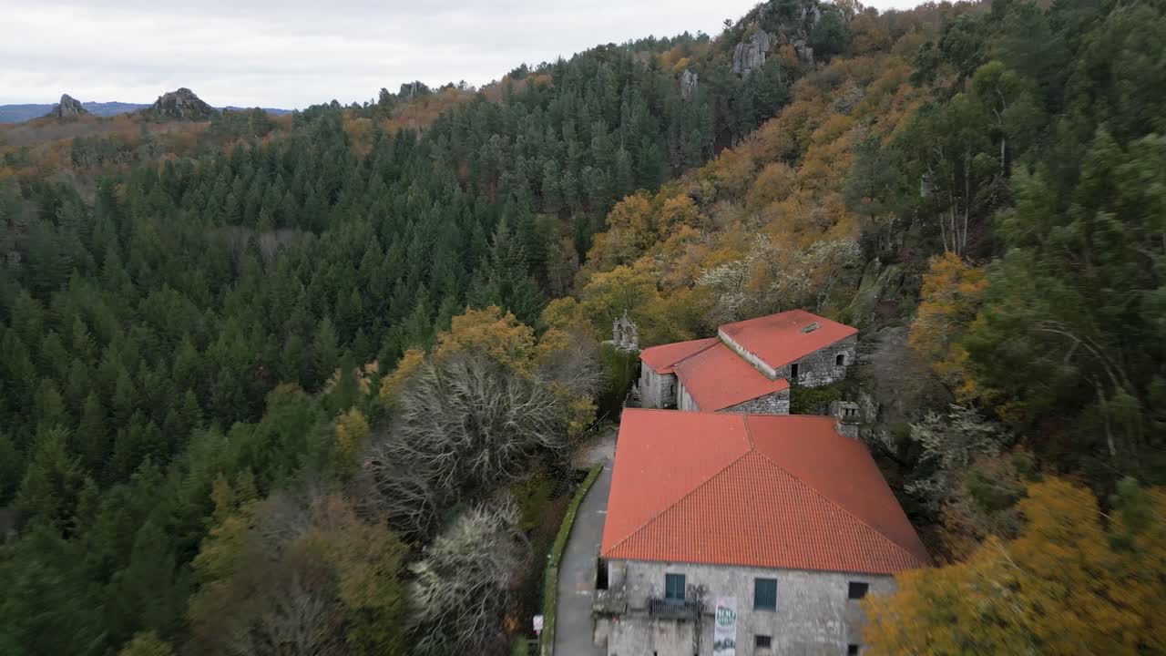 hermosa toma aérea de un viejo monasterio san pedro de rocas construcción rodeada de grandes árboles, naturaleza y montañas